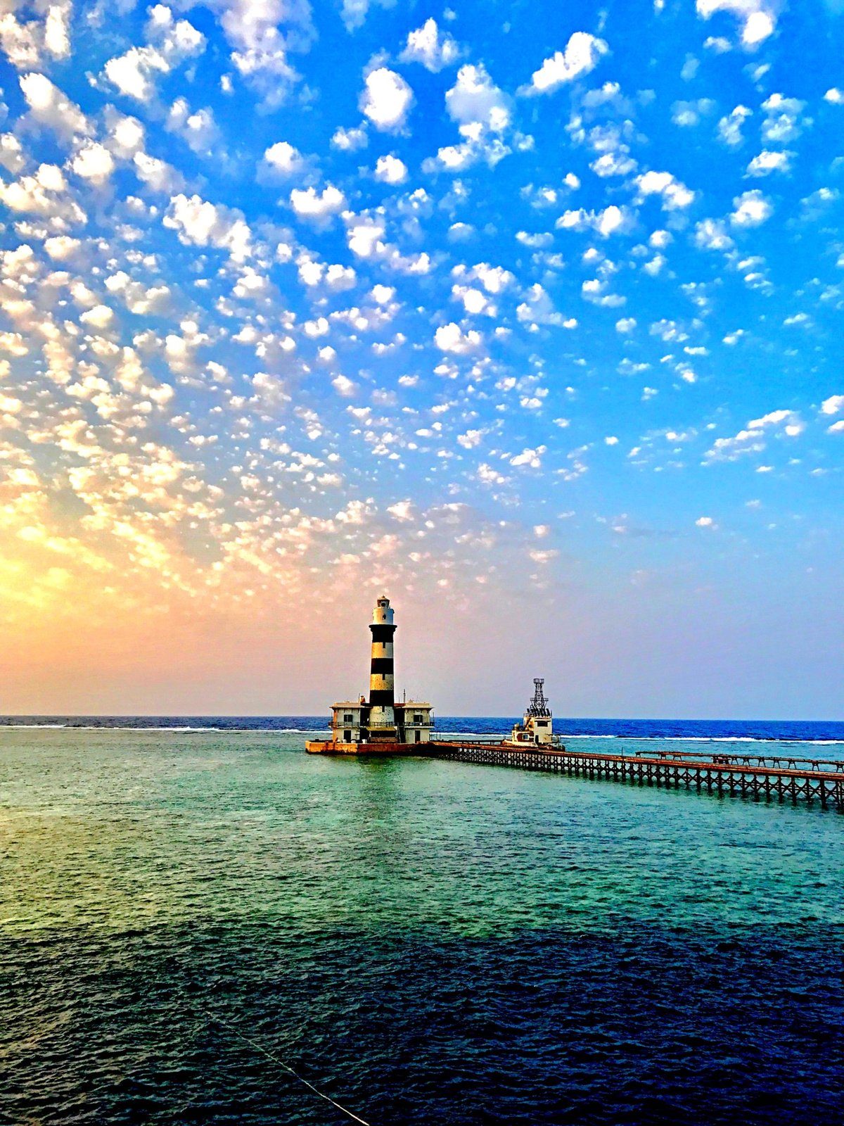Lighthouse and jetty at Daedalus Reef under a dramatic sky
